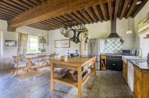 a kitchen with a wooden table and a dining room at Chateau de Villette in Poil