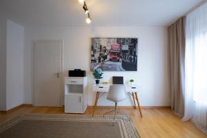 ein Wohnzimmer mit einem Schreibtisch und einem Bild an der Wand in der Unterkunft - Sweet Dreams - Gästeunterkunft Hannover in Hannover