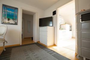ein Wohnzimmer mit einem TV und einer weißen Kommode in der Unterkunft - Sweet Dreams - Gästeunterkunft Hannover in Hannover