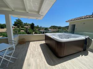 a hot tub on a patio with a table and chairs at Suimi's Hotel in Villasimius