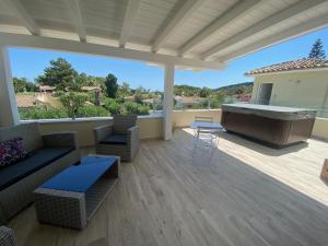 a large outdoor patio with a hot tub and furniture at Suimi's Hotel in Villasimius