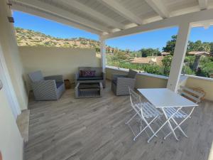 a porch with a table and chairs and a couch at Suimi's Hotel in Villasimius