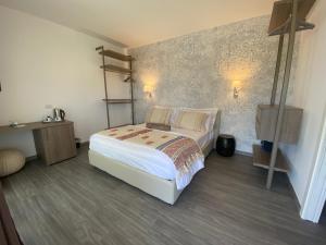 a bedroom with a white bed and a wall at Suimi's Hotel in Villasimius
