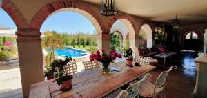 a dining room with a wooden table with flowers on it at Sandmartins Private Secure Villa in Simondium