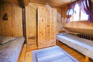 a room with two beds in a wooden cabin at Äksi pastoraadi sviit in Woldi