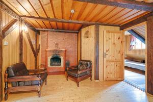 a living room with leather furniture and a fireplace at Äksi pastoraadi sviit in Woldi