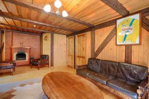 a living room with a leather couch and a table at Äksi pastoraadi sviit in Woldi