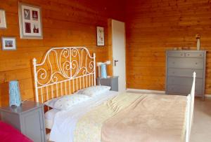 una camera con un letto bianco e una parete in legno di b&b L'Alloggio a Fermo