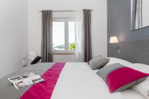 a bedroom with a large bed with a pink blanket at Apartments Zulijani House Helis B1 & B6 in Rabac