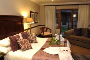 a bedroom with a bed and a living room at College Lodge in Bloemfontein