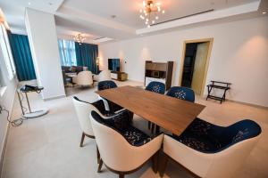 comedor con mesa de madera y sillas en Waterfront Hotel Apartment, en Lusail