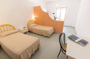 カーポ・ヴァチカーノにあるResidence Esmeraldoのベッド2台とテーブルと鏡のある部屋 +67枚の写真