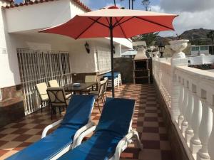 un patio con sillas y una sombrilla en el balcón en Bungalow Isla Margarita en Puerto Rico