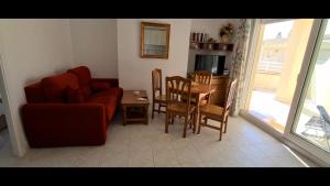 a living room with a red couch and a table at Atico con vistas al mar Primera línea Cala Montero - ALBERT VILLAS Alcossebre in Alcossebre