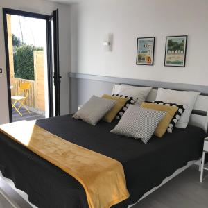 a bedroom with a large black bed with two pillows at le 25 l'océan in Saint-Hilaire-de-Riez