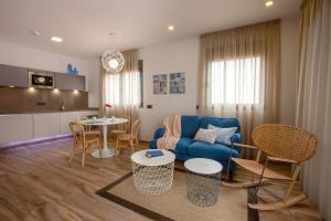 a living room with a blue couch and a table at Gran Marina Suites in Las Palmas de Gran Canaria