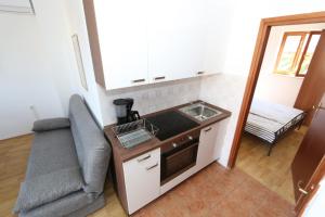 małą kuchnię ze zlewem i krzesłem w obiekcie Apartment in Stara Novalja with sea view, balcony, air conditioning, WiFi (4897-1) w mieście Stara Novalja +24 zdjęcia