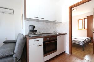 kuchnia ze zlewem i kuchenką w obiekcie Apartment in Stara Novalja with sea view, balcony, air conditioning, WiFi (4897-1) w mieście Stara Novalja