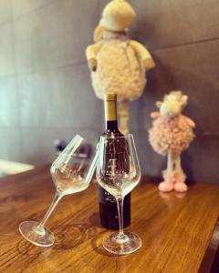 a bottle of wine and two wine glasses on a table at Apartment Klet in Sisak