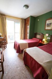 ein Hotelzimmer mit zwei Betten und einem Fenster in der Unterkunft Hotel Arunda II in Ronda