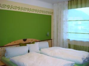 una camera con due letti e una parete verde di Gästehaus Christine a Langkampfen