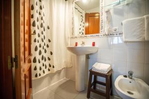 ein weißes Badezimmer mit Waschbecken und Spiegel in der Unterkunft Hotel Arunda II in Ronda + 37 Fotos
