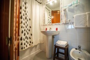 ein Badezimmer mit Waschbecken und Spiegel in der Unterkunft Hotel Arunda II in Ronda