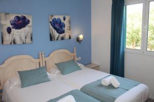 1 dormitorio con 2 camas y paredes azules en Villa INGRID, en Cala en Forcat