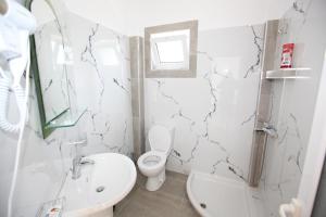 uma casa de banho branca com um WC e um lavatório em Hotel Real em Saranda