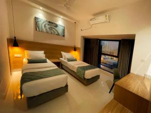 a hotel room with two beds and a window at Eiffel Suites - Kammanahalli in Bangalore