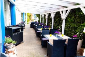 - une rangée de tables et de chaises sur la terrasse dans l'établissement Hotel Röhrsdorfer Hof, à Chemnitz
