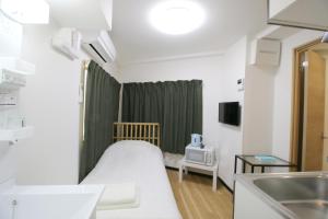 a hospital room with a bed and a sink at Uhome千駄木静雅民宿旅馆 in Tokyo