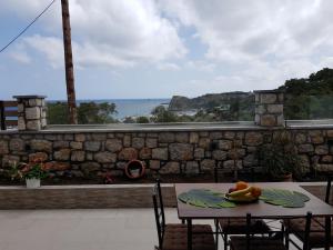 una mesa con fruta en la parte superior de una pared de piedra en Galazia Thea Apartments, en Archangelos