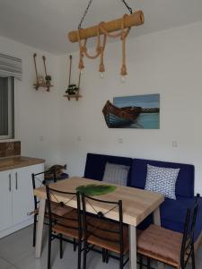 mesa de comedor con sillas y sofá azul en Galazia Thea Apartments, en Archangelos