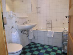 a bathroom with a sink and a toilet and a tub at Der Seehof Rheinsberg in Rheinsberg