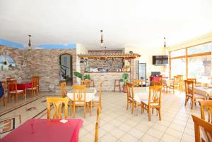 a restaurant with tables and chairs and a brick wall at Hotel Real in Sarandë