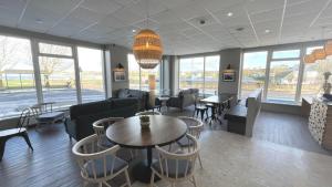 a dining room table with chairs and a large window at Marine Hotel Ballycastle in Ballycastle