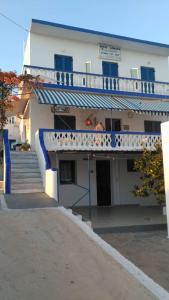 un edificio con balcón y escaleras delante de él en Hotel Glaros Lipsi en Lipsoi