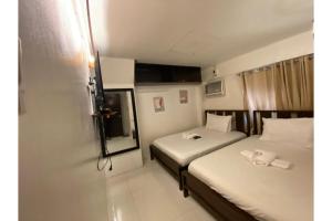 a small room with two beds and a mirror at E Relaxed Haven Transient House in Manila