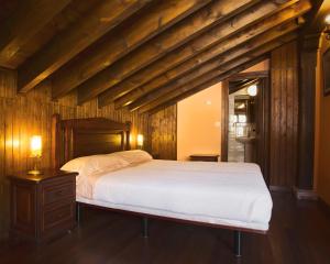 1 dormitorio con 1 cama grande y techo de madera en La Hospedería de Salamón, en Salamón