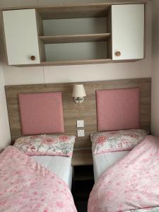 two beds in a small room with pink beds at The Wimbledon in Dunoon
