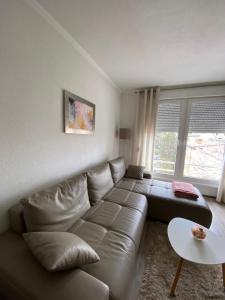 a living room with a leather couch and a table at Stan-apartman A&A in Banja Luka