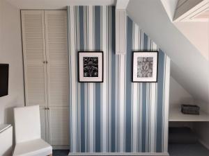 a staircase with three pictures on a striped wall at Polskie Morze Apartamenty & Pokoje in Pobierowo +109 photos
