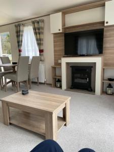 a living room with a table and a fireplace with a tv at The Wimbledon in Dunoon