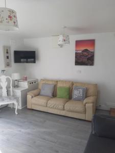 a living room with a couch and a tv at Lorna's Apartment Self Catering Holiday Home in Miltown Malbay