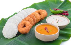a plate of food on a banana leaf with dipping sauce at PHP BOUTIQUE TOWNHOUSE in Chennai