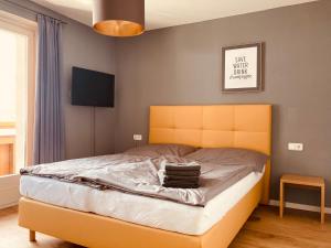 a bedroom with a bed with a yellow headboard at Alpensoul Apartments in Zell am See