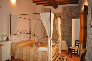 une chambre avec un lit à baldaquin dans l'établissement Agriturismo Morisfarms - Santa Laura, à Cura Nuova
