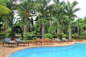 a table and chairs next to a swimming pool at Chanya Lodge in Moshi