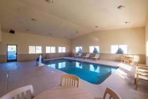 une grande piscine intérieure avec des chaises et une table dans l'établissement Comfort Inn Near Gila National Forest, à Silver City